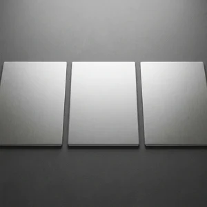 Tiga potongan pelat stainless steel dengan permukaan brushed disusun berdampingan di atas permukaan gelap